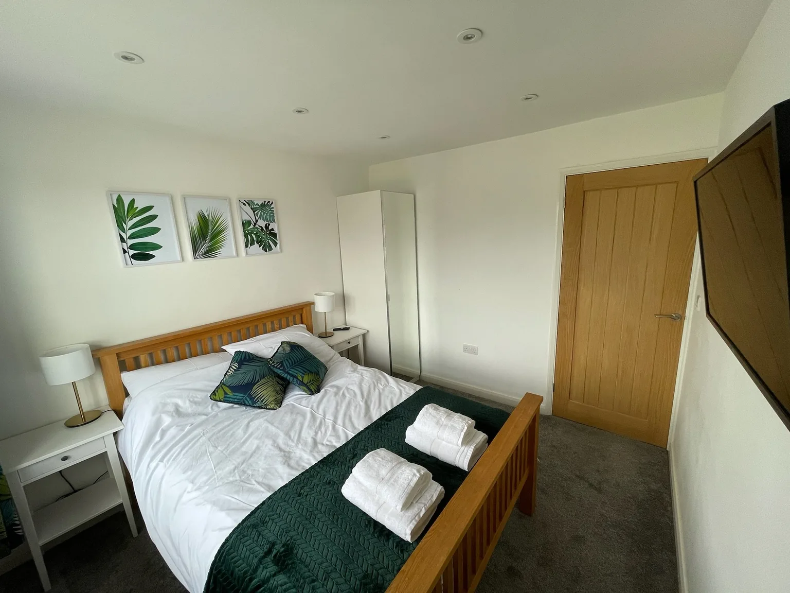 Double bedroom with green bedspread and bedside tables