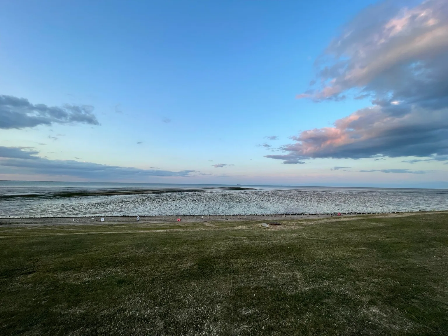 Open grassy seafront beside the beach