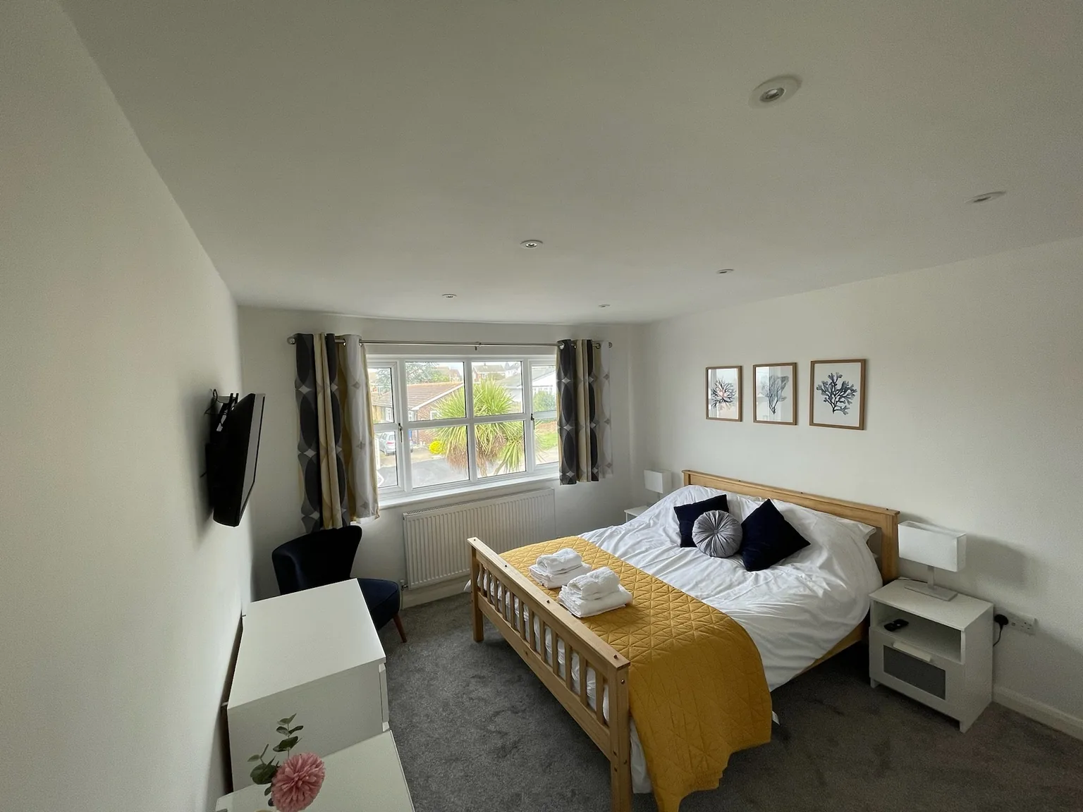 King bedroom with yellow bedspread and television